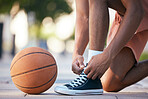 Hands, shoes and basketball in sports motivation for exercise, workout and exercise in the outdoors. Hand of sport player tying lace for ball game, match or training in healthy cardio fitness outside