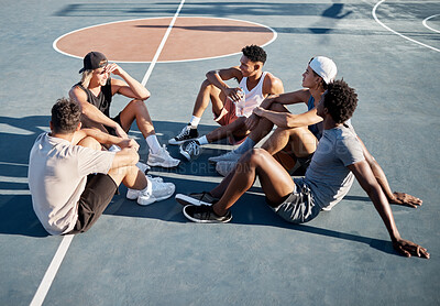 Buy stock photo Fitness, friends and relax on basketball court floor with basketball players group bond, resting and talking on a break. Sports, resting and men sitting on the ground at outdoor court after training