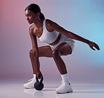 Fitness, exercise and woman with a kettlebell in studio strength training and burning calories in a full body exercise. Energy, workout and healthy girl swings a heavy weight for strong arms and legs