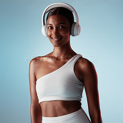 Buy stock photo Radio, smile and woman with headphones for music, podcast or motivation during exercise against a blue mockup studio background. Audio, happy and Indian girl training for fitness, energy and cardio