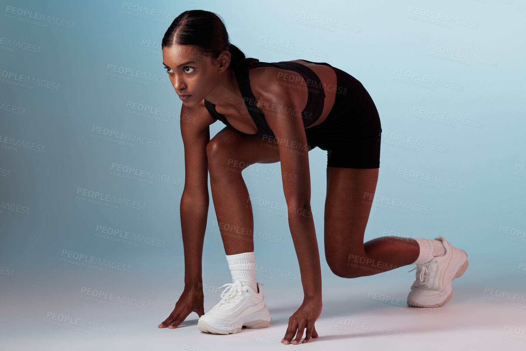 Buy stock photo Fitness, runner and commitment of athlete woman ready to start running, race or marathon on blue background for health, wellness and sports training. Female from India for exercise workout motivation