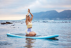 Yoga, beach and woman in the water for meditation, training of mind and spiritual wellness. Peace, relax and girl with faith, zen and motivation while surfing on a surfboard in the sea in summer