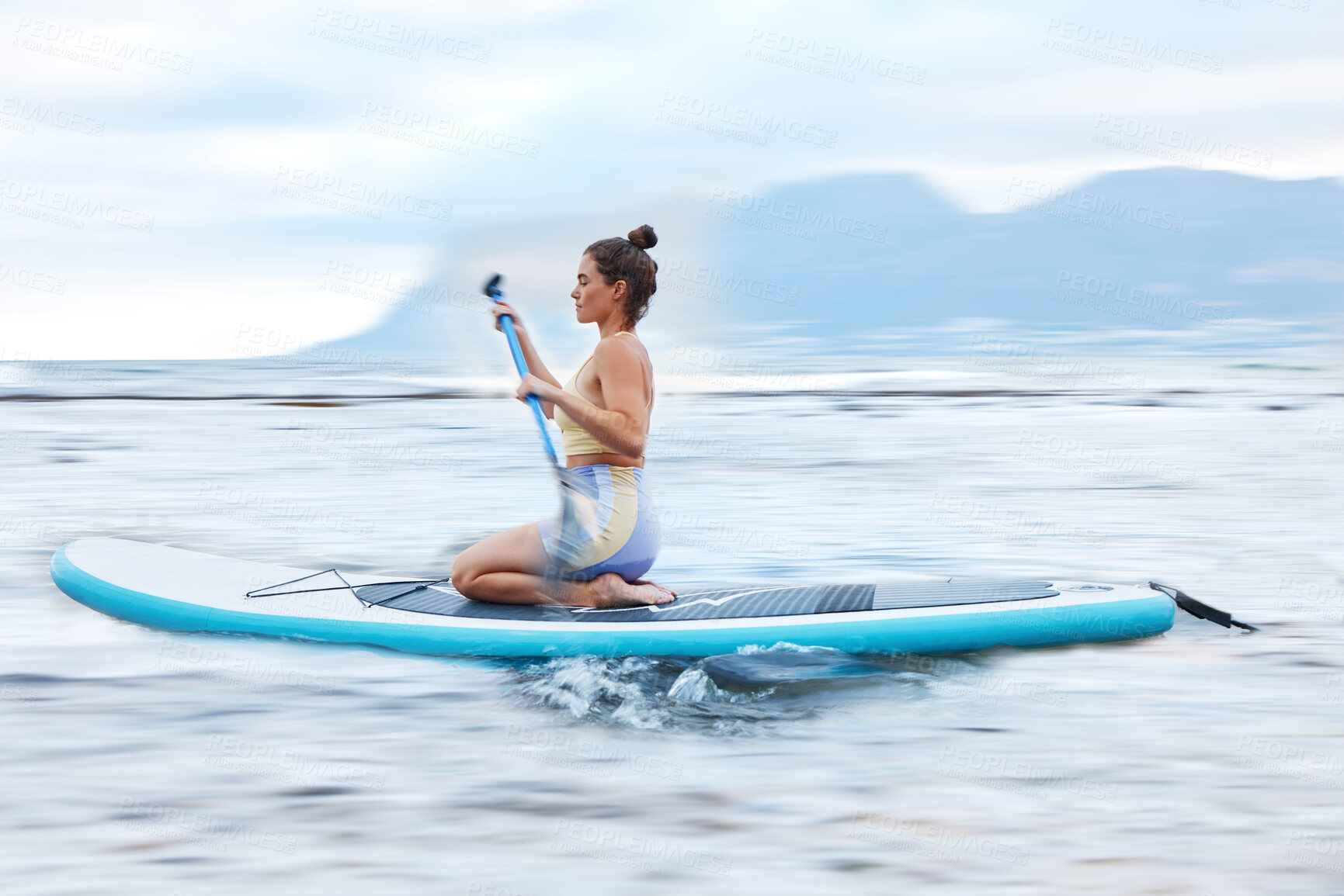 Buy stock photo Paddle board, sea and fitness with a sports woman floating on water in nature for wellness or exercise. Earth, training and travel with a female athlete on a paddleboard while on vacation for travel