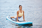 Surfing board yoga, woman and cobra pose for exercise, workout and training on water, sea and ocean for freedom, energy and wellness. Paddle board fitness, meditation and stretching pilates in nature