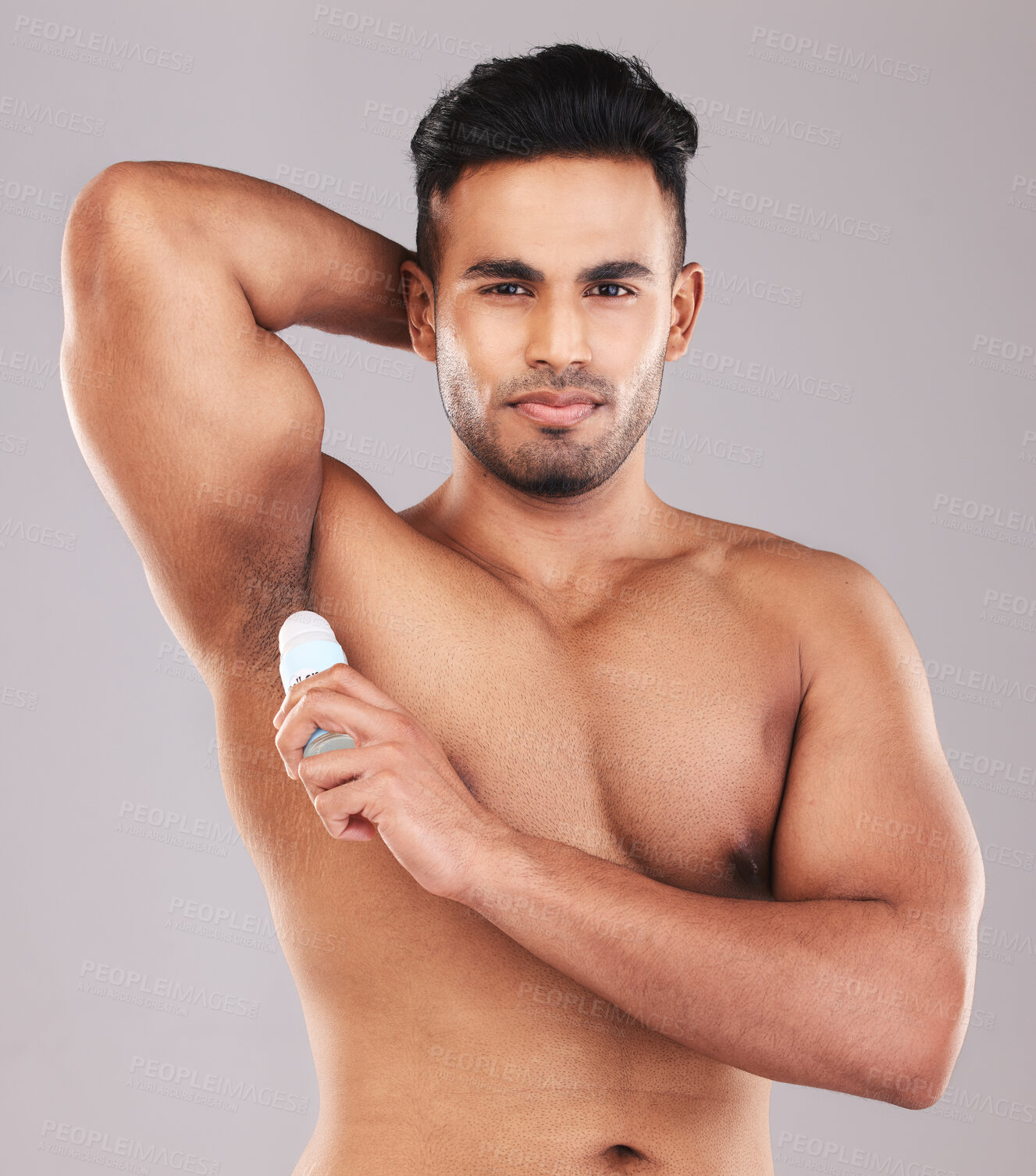 Buy stock photo Deodorant, health and man cleaning armpit against a grey studio background. Wellness, care and portrait of a young model with an underarm product for grooming, clean skin and care for body hygiene