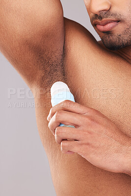 Buy stock photo Deodorant, health and man cleaning armpit for wellness, skin and care for body against a grey studio background. Grooming, hygiene and underarm of a person with a product to clean and stop sweat
