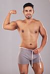 Weight loss, fitness and man with muscle from training, diet and exercise against grey studio background. Motivation, happy and portrait of person with tape to measure goal body and healthy lifestyle