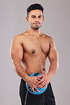 Fitness, portrait and man with a medicine ball for sports, workout and exercise against a grey studio background. Wellness, training and portrait of a young Arab athlete happy with body cardio