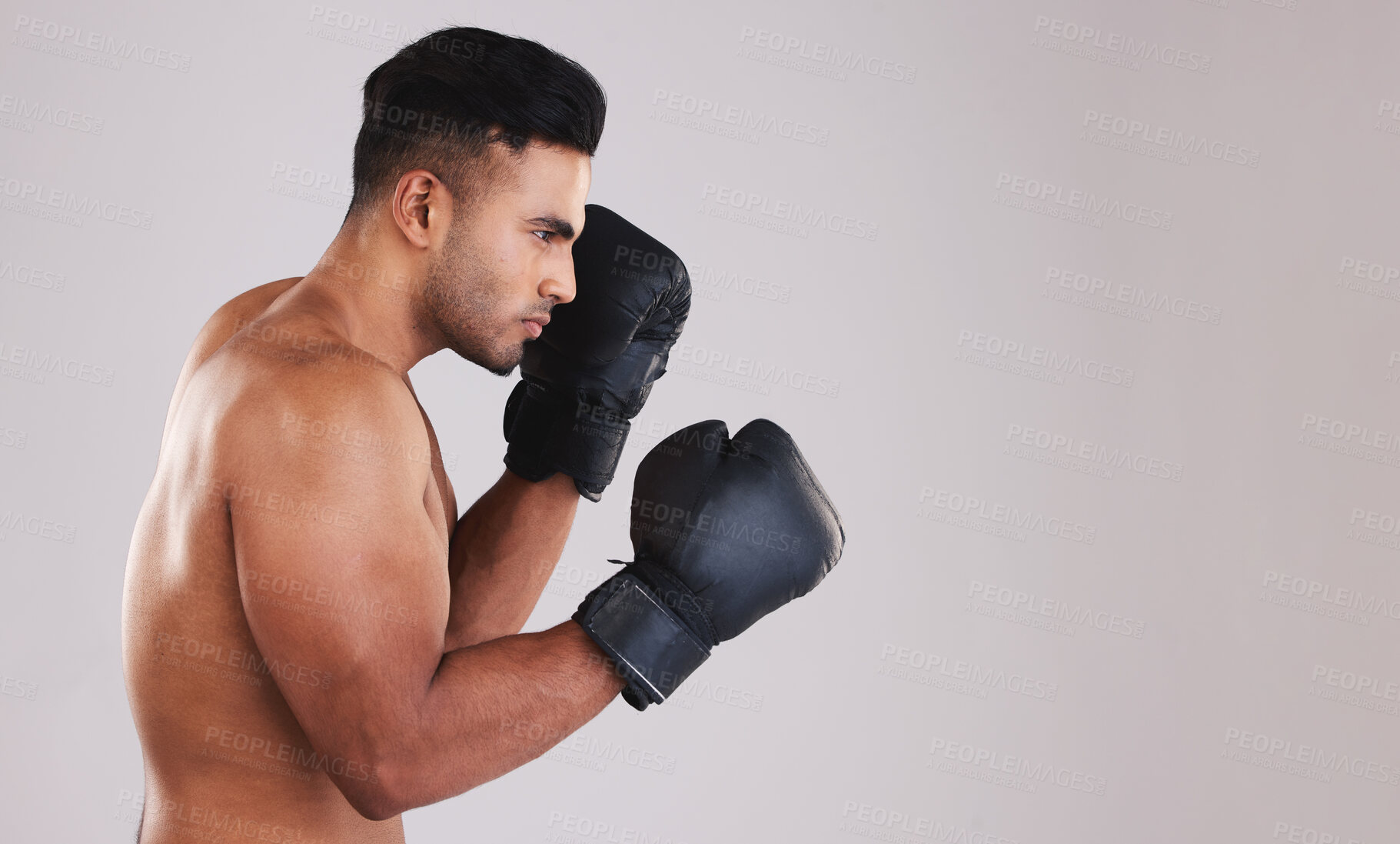 Buy stock photo Training, young man and boxer with boxing gloves for competition, prepare for match and focus with grey studio background profile. Sportsman, Indian male and fighter at game, being healthy in workout