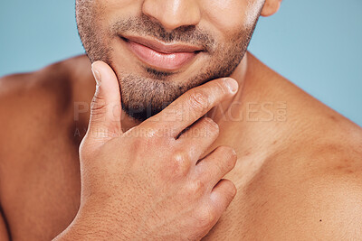 Buy stock photo Hands, face and beauty with a man model posing in studio on a blue background for skincare or grooming. Cleaning, bathroom and wellness with a young male indoors to promote a natural cosmetic product