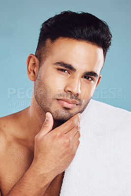 Buy stock photo Hand, face and beauty with a man model posing in studio on a blue background for grooming or skincare. Portrait, luxury and wellness with a male indoors to promote a natural product or skin treatment