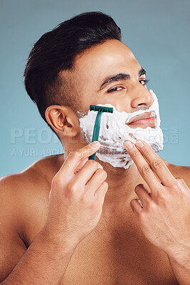 Buy stock photo Beauty, skincare and man shaving beard for clean face for dermatology, health and wellness on blue studio background. India male model with foam for healthy skin after facial shave and self care