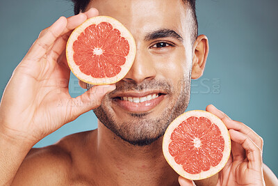 Buy stock photo Man, face and grapefruit skincare natural citrus vitamin c treatment. Facial wellness, healthy fruit lifestyle and portrait of happy male healthcare or cosmetic skin detox in blue background studio