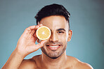Happy studio portrait, man lemon skincare for beauty wellness and face health against blue backdrop. Young happiness model, cosmetic fruit for healthy skin or facial shine glow with wall background