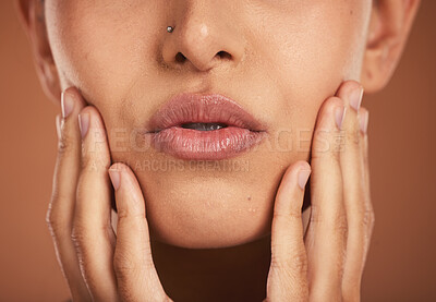 Buy stock photo Beauty, makeup and hands by lips of woman for cosmetics, facial and skincare. Beauty products, cosmetology and closeup of girl with lipstick, kiss pose and touching face in studio on brown background