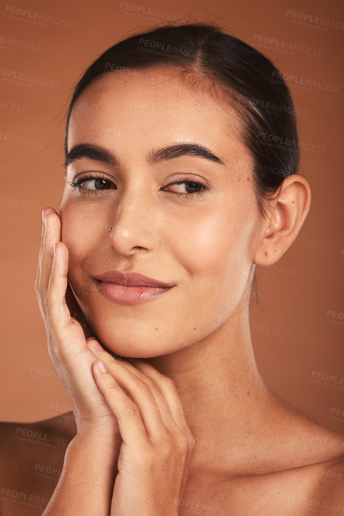 Buy stock photo Skincare, beauty and face of Latina woman with smile, healthy and natural skin. Makeup, cosmetics and girl pose with hands for skincare products, spa and wellness isolated on brown background studio