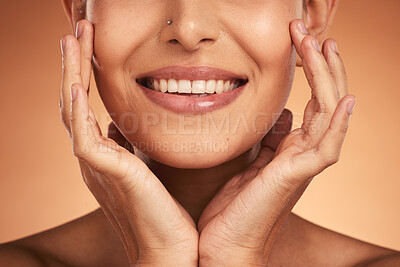 Buy stock photo Hands, mouth and beauty with a model woman in studio on a beige background to promote wellness with a smile. Cosmetics, skincare and happy with a female posing to promote natural treatment or product