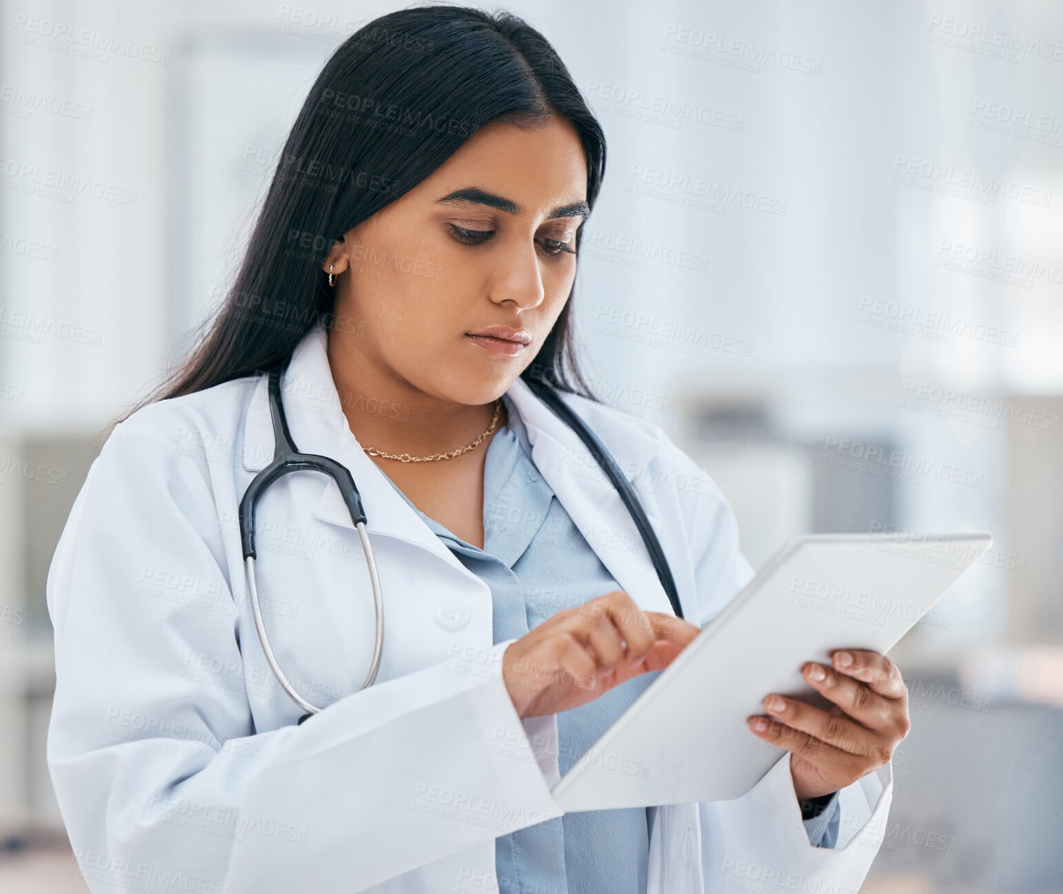 Buy stock photo Health, healthcare and doctor on tablet in hospital working on patient records, researching medicine and planning schedule. Medical professional, female and worker from India on tech browsing web.