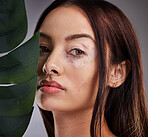 Beauty, leaf and woman with vitiligo in studio for wellness, skincare and luxury grooming on grey background mockup. Portrait, plant and face of dermatology model relax with natural facial product