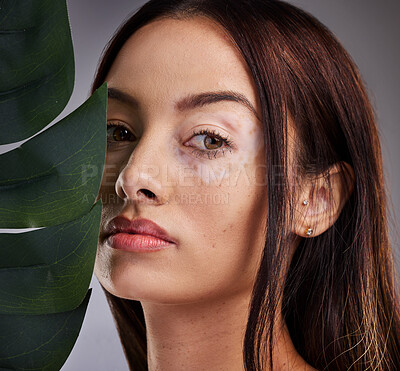 Buy stock photo Beauty, leaf and woman with vitiligo in studio for wellness, skincare and luxury grooming on grey background mockup. Portrait, plant and face of dermatology model relax with natural facial product