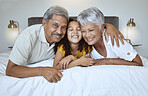 Love, bonding and mature people with child bonding while relaxing on the bed at home. Grandmother, grandfather and grandchild resting with affection and bond in their house bedroom for loving oomfort