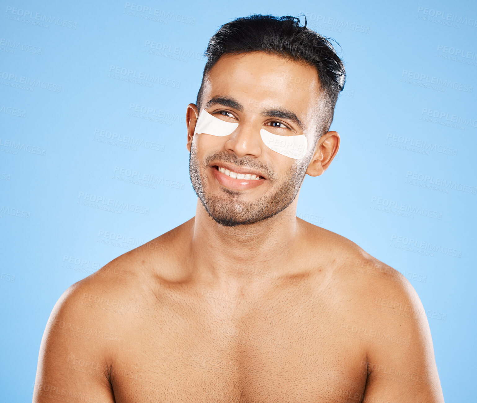 Buy stock photo Skincare, eyes patch and man beauty, dermatology and body cosmetics of wellness, facial treatment or collagen eye care mask on studio blue background. Happy arab guy use healthy face for dark circles