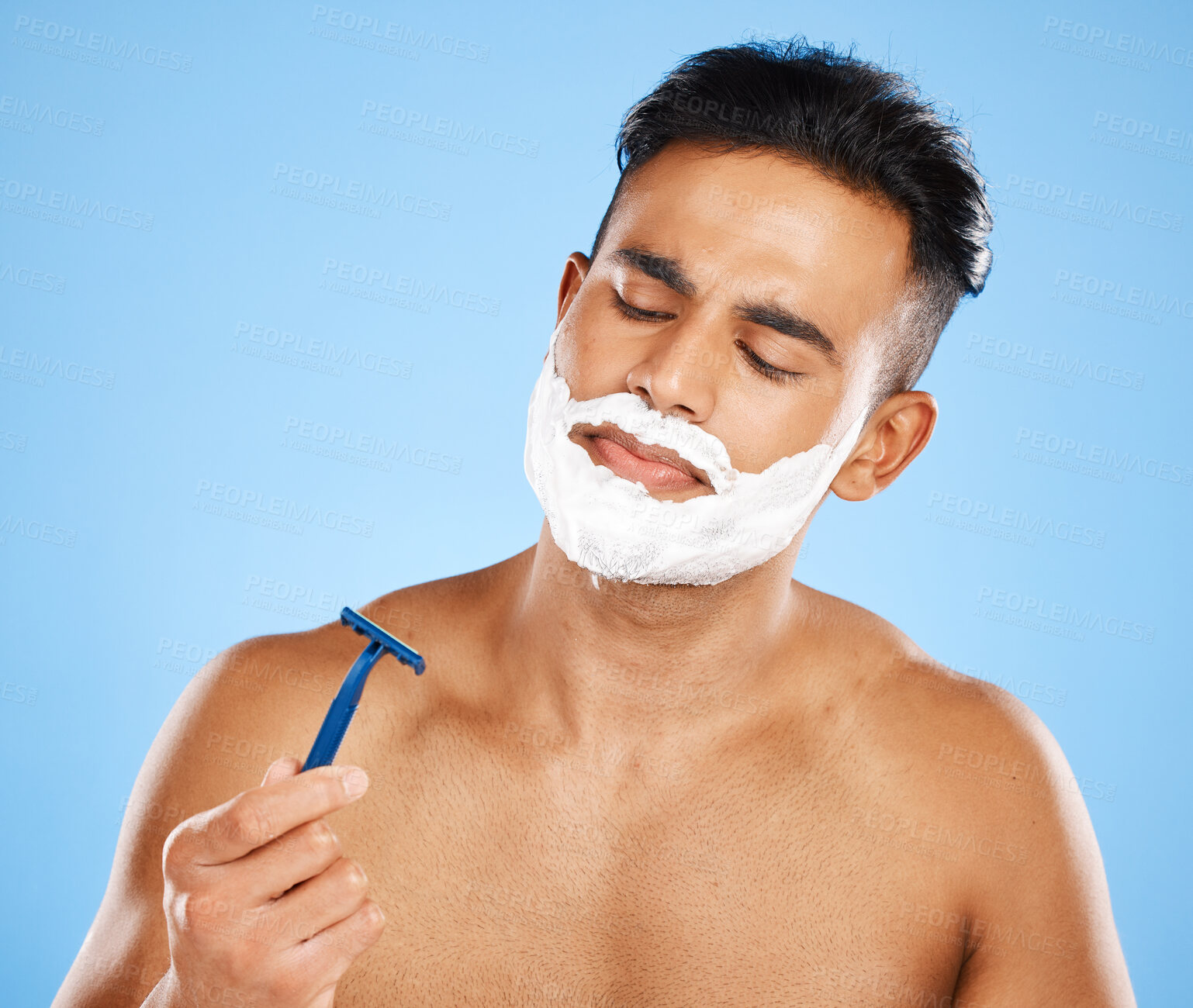 Buy stock photo Shaving, grooming and hygiene, man with razor for clean and fresh face, cream and foam product with blue studio background. Facial wellness, healthy skin and skincare, beauty and check blade.