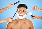 Face, shave and grooming with hands holding equipment for shaving or brushing hair in studio on a blue background. Skincare, wellness and luxury with an unhappy male customer at the barber for beauty