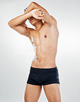 Body, topless and health with a masculine man posing in studio on a gray background in his underwear. Fitness, exercise and healthy with a macho model male indoors to promote natural bodycare