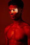Red, light and body, beauty and man isolated on studio background. Neon light, serious facial expression and male model from Brazil thinking, lost in thought or focus on fitness, health and wellness.