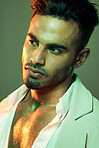 Fashion, green light and man in studio isolated on a green background. Neon light, beauty and aesthetic of male model from India in designer jacket thinking, contemplating and posing in cool clothing