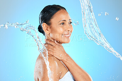 Buy stock photo Mature woman, wet or water splash on blue background in studio skincare wellness, hygiene maintenance or body cleaning. Smile, happy or beauty model with pouring liquid healthcare or hydration motion
