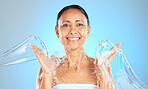 Water splash, woman and beauty portrait on blue background, skincare or facial wellness, body care and shower, cleaning and personal hygiene. Mature studio model, water stream and aesthetic hydration