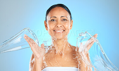 Buy stock photo Water splash, woman and beauty portrait on blue background, skincare or facial wellness, body care and shower, cleaning and personal hygiene. Mature studio model, water stream and aesthetic hydration