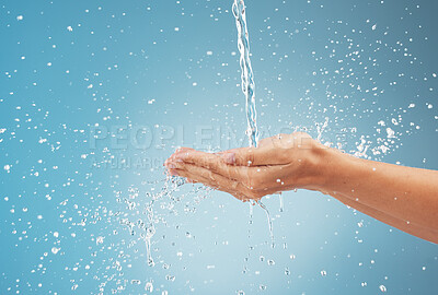 Buy stock photo Woman, hands and water splash on blue background in studio for healthcare, cleaning and washing hands. Zoom, model and pouring fresh faucet liquid in earth sustainability, conservation and protection