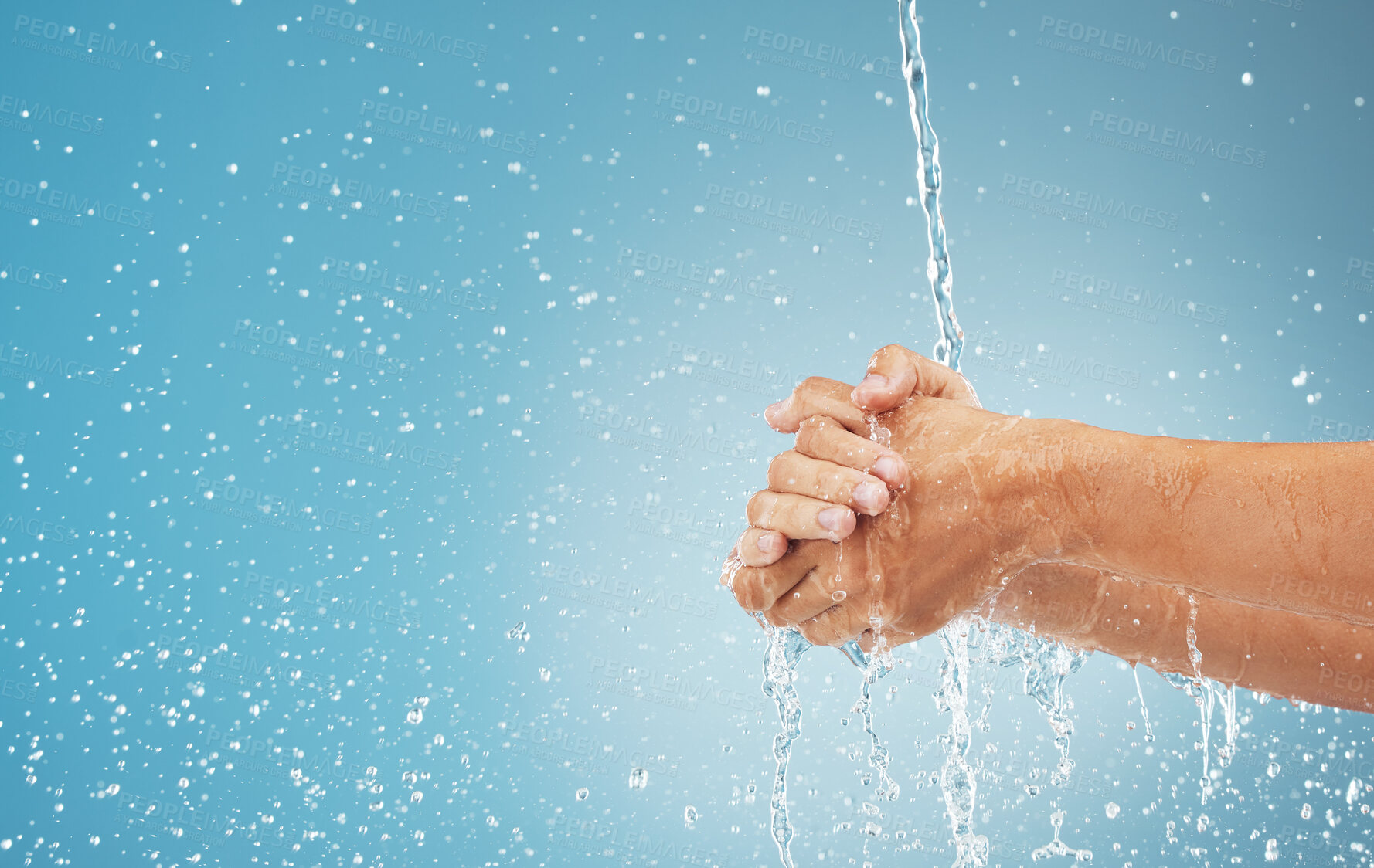 Buy stock photo Water splash, cleaning hands and hygiene on blue background, advertising or product placement space. Health, skincare and safety from germs or bacteria, man washing hand in water in studio background