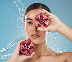 Pomegranate, skincare and beauty woman with water splash in studio blue mock up for healthy, wellness and skin glow advertising. Young woman with vitamin c fruits for facial product marketing mockup