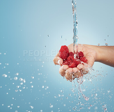 Buy stock photo Hands with raspberry, water splash and studio mockup on blue background of summer fruit sustainability, healthy lifestyle and detox, nutrition and vitamin c. Clean, vegan and diet red berries in palm