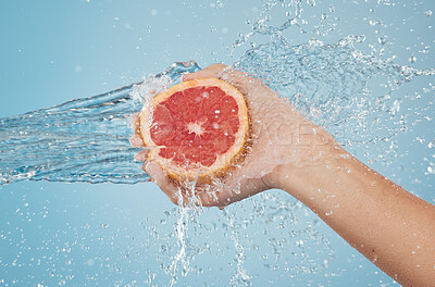 Buy stock photo Fruit, water and hand splash for beauty, care and healthy skincare and bodycare on a blue studio background. Grapefruit, hands and hygiene with vitamin c for organic and natural body skin cleansing