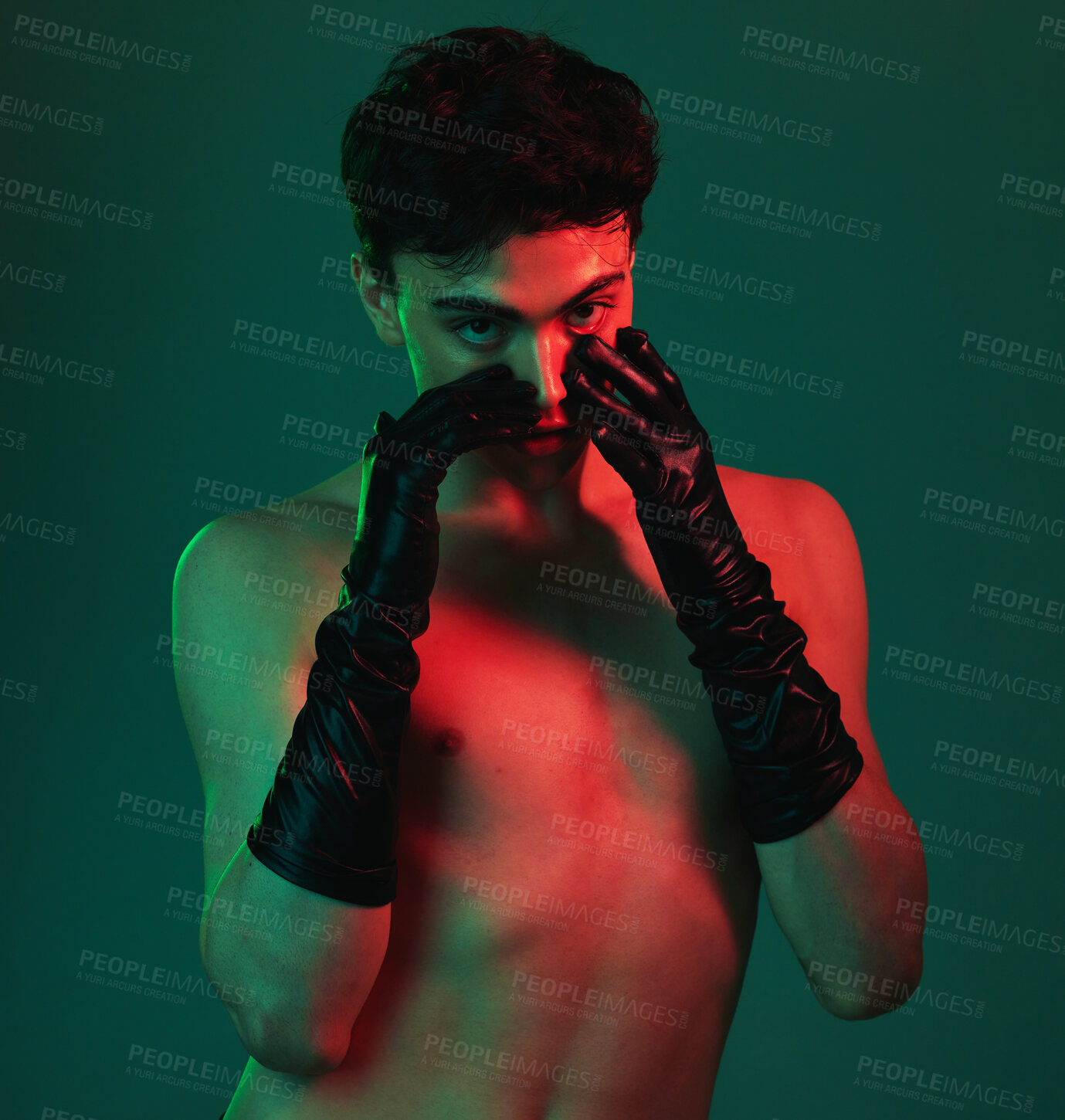 Buy stock photo Beauty, sensual and model with a shirtless man posing in studio on a green background with light for creative art. Portrait, topless and desire with a sexy young male in gloves proud of his body