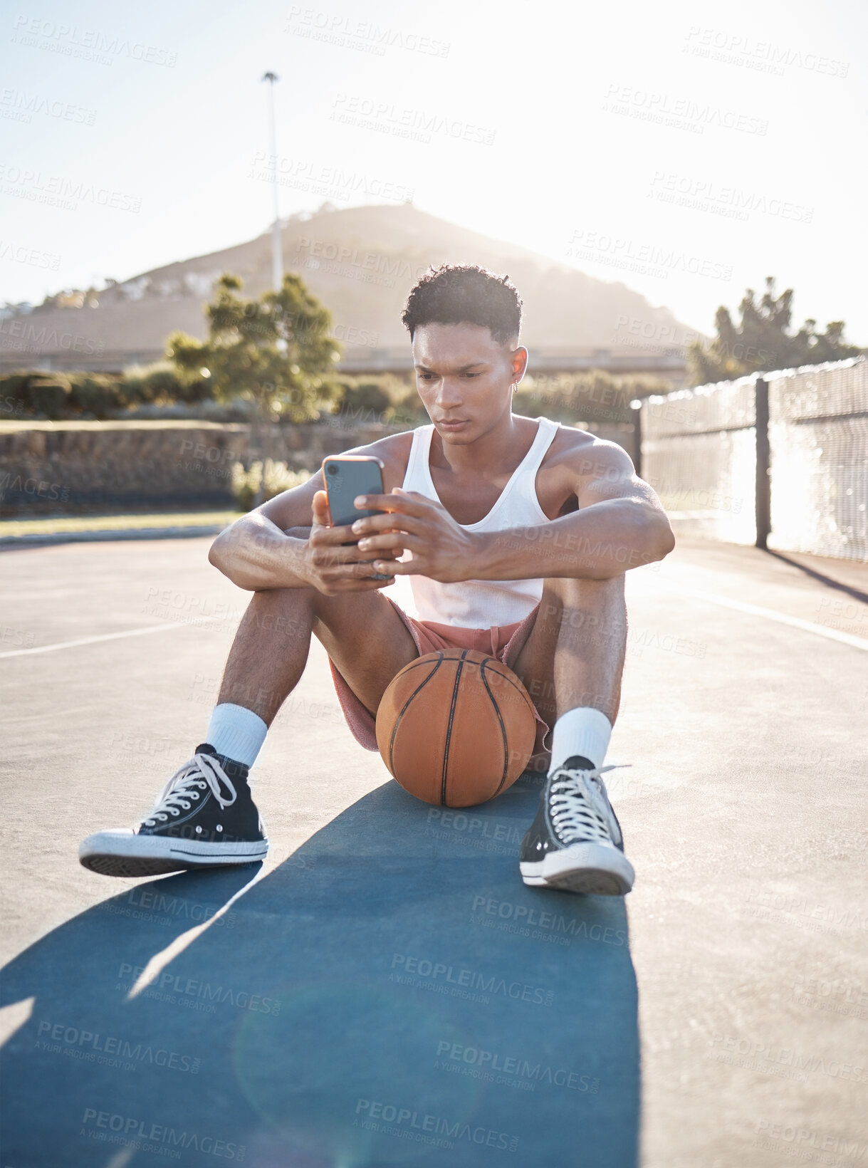 Buy stock photo Phone, fitness and basketball man relax typing training results on mobile app, gaming or reading blog update. Basketball player teen on ground and 5g smartphone using phone for social media