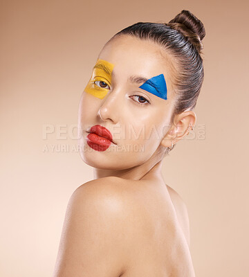 Buy stock photo Beauty, makeup and clown by woman in studio for fun, art and creative expression against a brown background with mockup. Face, portrait and pigment cosmetic product with girl model circus aesthetic  