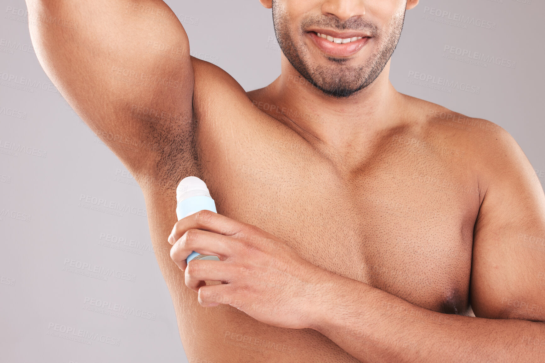 Buy stock photo Deodorant, underarm and grooming with a man model in studio on a gray background for hygiene or scent. Wellness, cosmetics and body with a male applying rollon to promote a product for fresh aroma