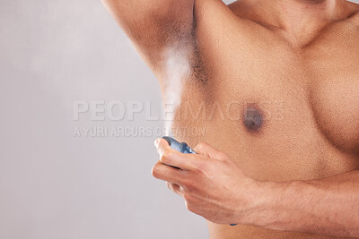 Buy stock photo Deodorant, spray and man cleaning his armpit for health, beauty and hygiene against a grey mockup studio background. Antiperspirant, clean and model with a bottle for underarm with mock up space