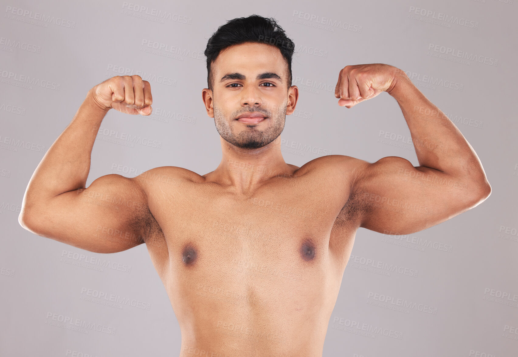 Buy stock photo Fitness, portrait and man flexing muscle on gray studio background. Sports, wellness and proud Indian body builder showing biceps, power and arm strength during training, exercise or body workout.
