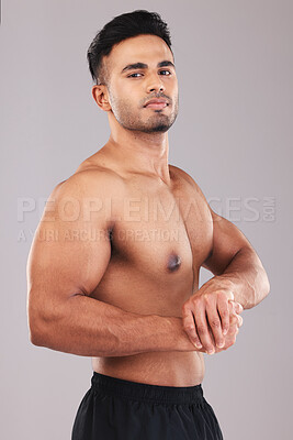 Buy stock photo Bodybuilder, health and fitness with a masculine man in studio on a gray background for exercise motivation. Portrait, gym and model with a male athlete posing to show his muscle, bicep or body