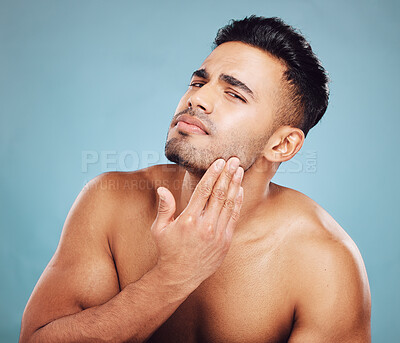 Buy stock photo Man, skincare and touch cosmetics face check on skin, beard or skin tone for health by blue studio background. Model, handsome beauty facial or inspection for natural cleaning, glow or cosmetic