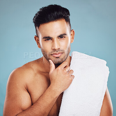 Buy stock photo Skincare, health and face of model from India posing for health, wellness and dermatology after cleaning, facial or shaving against blue background. Portrait of beauty man with towel for self care