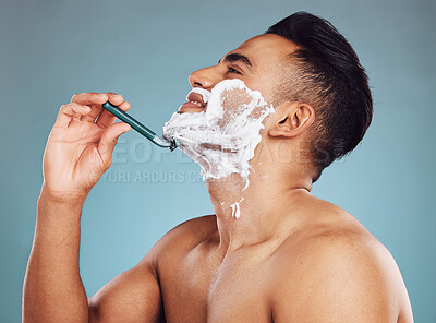 Buy stock photo Studio, skincare and man shaving his beard in a daily morning grooming routine with a razor in Mexico. Smile, wellness and happy Latino person shaves his mustache or facial hair for self care hygiene