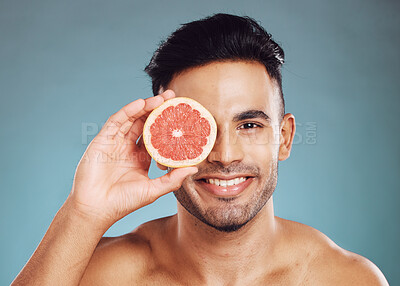 Buy stock photo Grapefruit, man and skincare in studio for vitamin c, healthy wellness and natural glow on blue background. Portrait of happy guy model face, nutrition and body detox for cleaning beauty cosmetics 